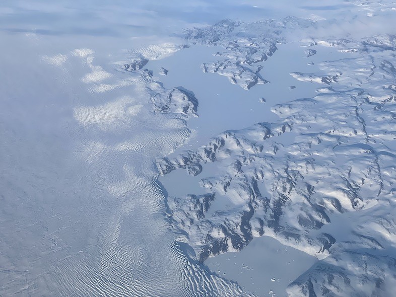 The change in ice surface is reflective of how fast and over what it moves. The flat surface shows floating ice, the wrinkles and ridges show ice that is accelerating compared to the ice around it. ice movement