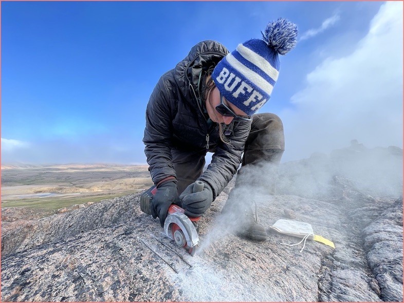 Karlee Prince cuts into the bedrock with a drill to extract a rock sample. Karlee Prince drilling